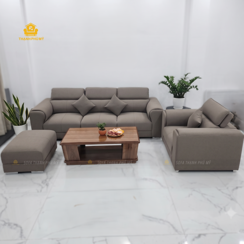 Toàn cảnh bộ sofa văng 2m6 kèm ghế đơn và đôn bọc da microfiber màu nâu xám nhạt vân bắt sáng, đặt đóng tại xưởng Nội Thất Thạnh Phú Mỹ, Buôn Ma Thuột, Đắk Lắk.