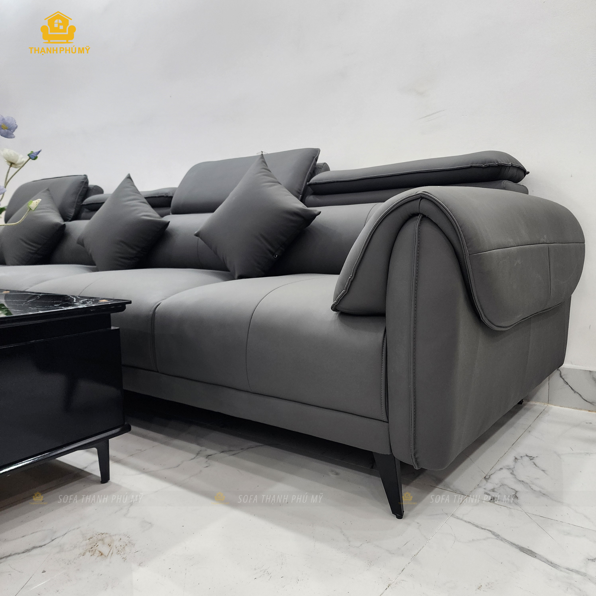 Cận cảnh tay vịn và tựa lưng sofa góc L da simili màu xám, thấy rõ đường chỉ may và viền đệm – Sofa Thạnh Phú Mỹ