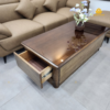 Văn bản thay thế (Alt text): Bề mặt kính màu trà cao cấp phản chiếu ánh sáng tinh tế trên mẫu bàn sofa gỗ sồi Buôn Ma Thuột.