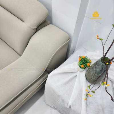 Sofa Microfiber màu be sáng phối cùng nền trắng và phụ kiện trang trí trung tính.